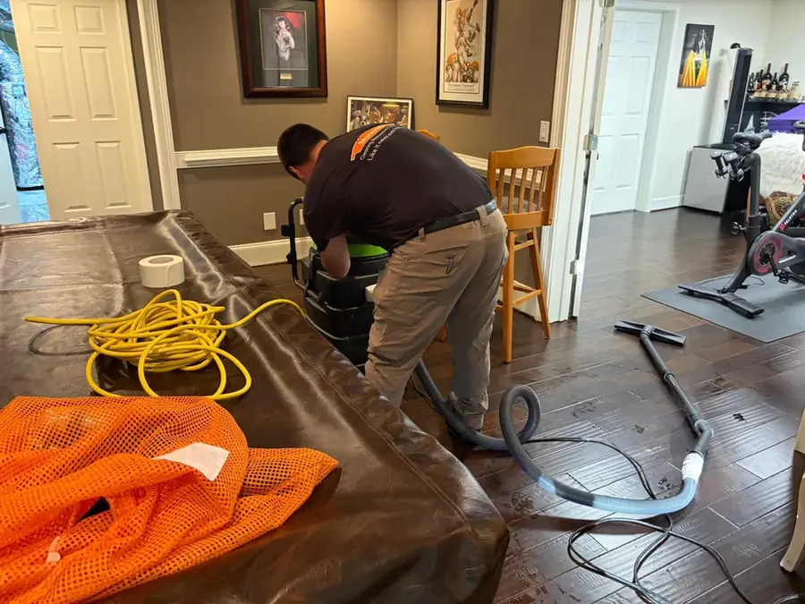 A technician drying a hardwood floor after a leak